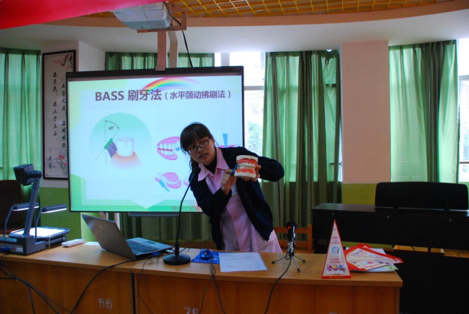 卫生中心医生用模型向同学们展示正确的刷牙方法